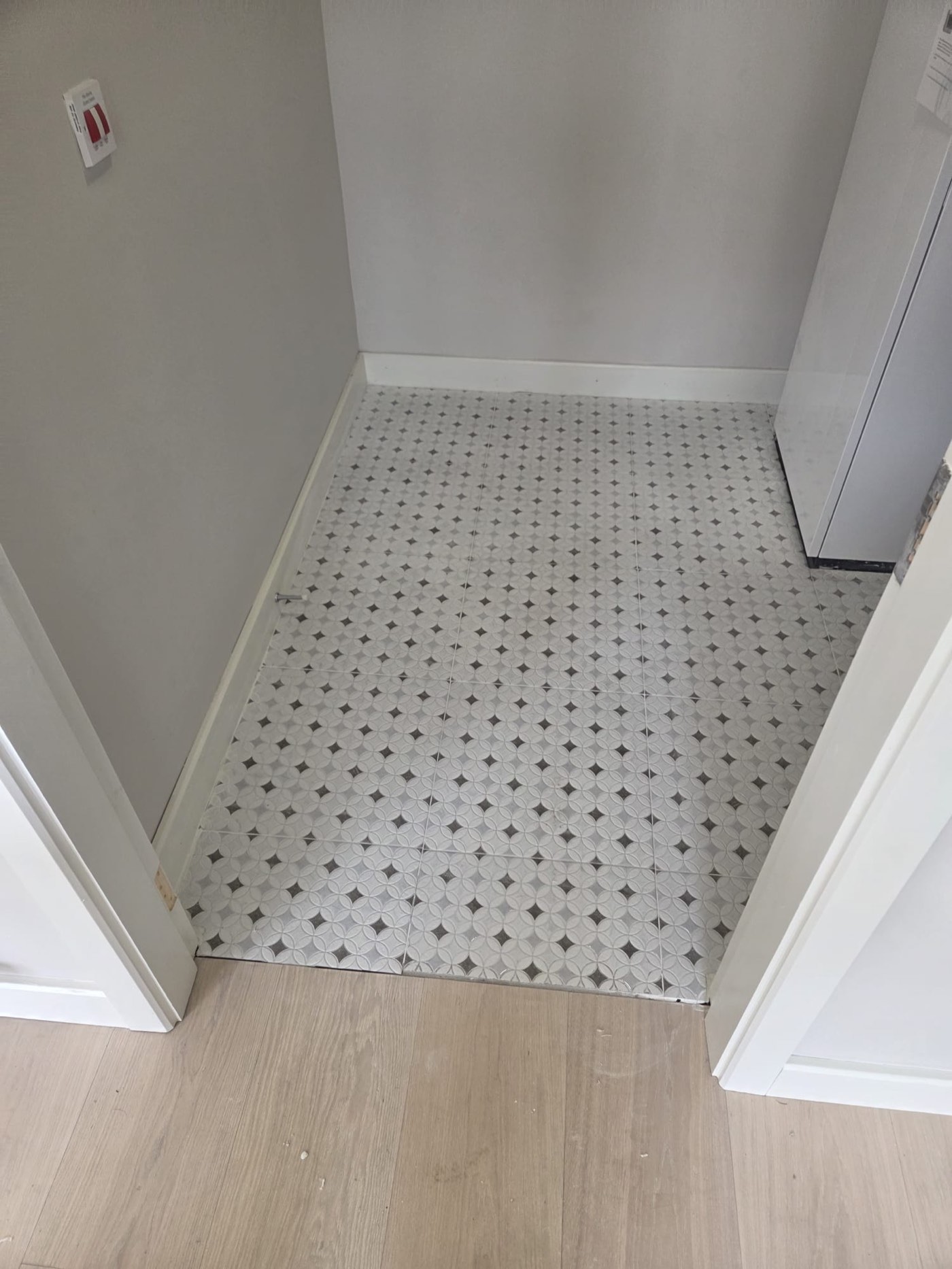 Patterned floor tiles with new skirting boards meeting laminate flooring fitted in Dublin home