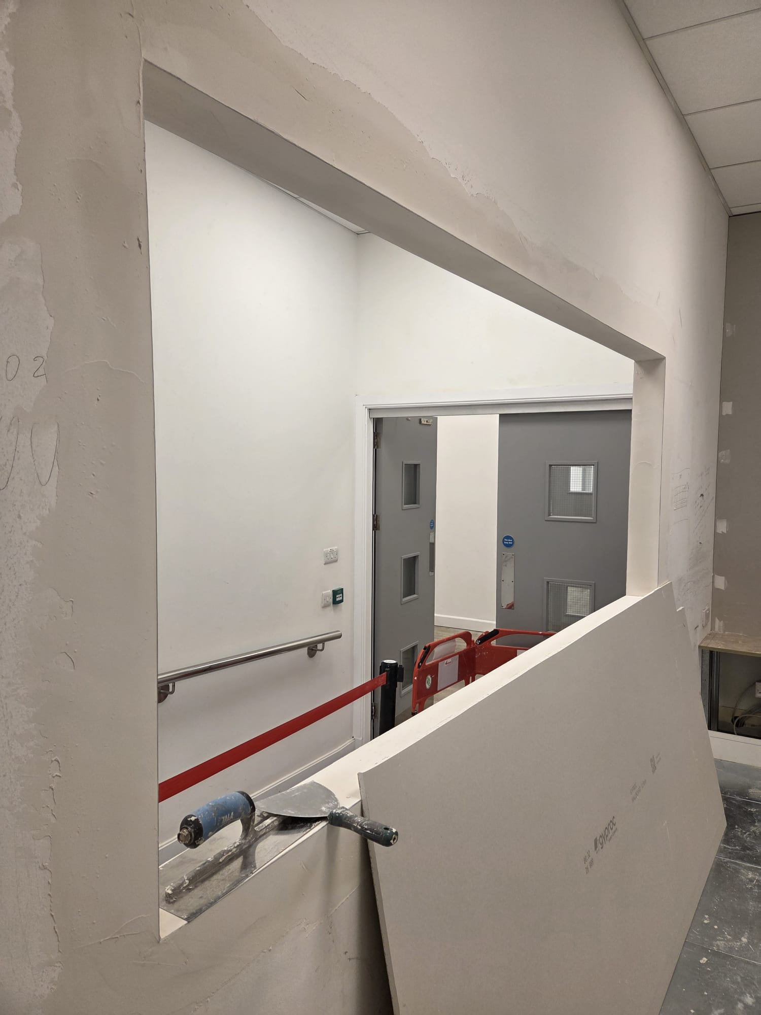 Plastering around reception hatch opening with plasterboard installation in Dublin commercial fit-out