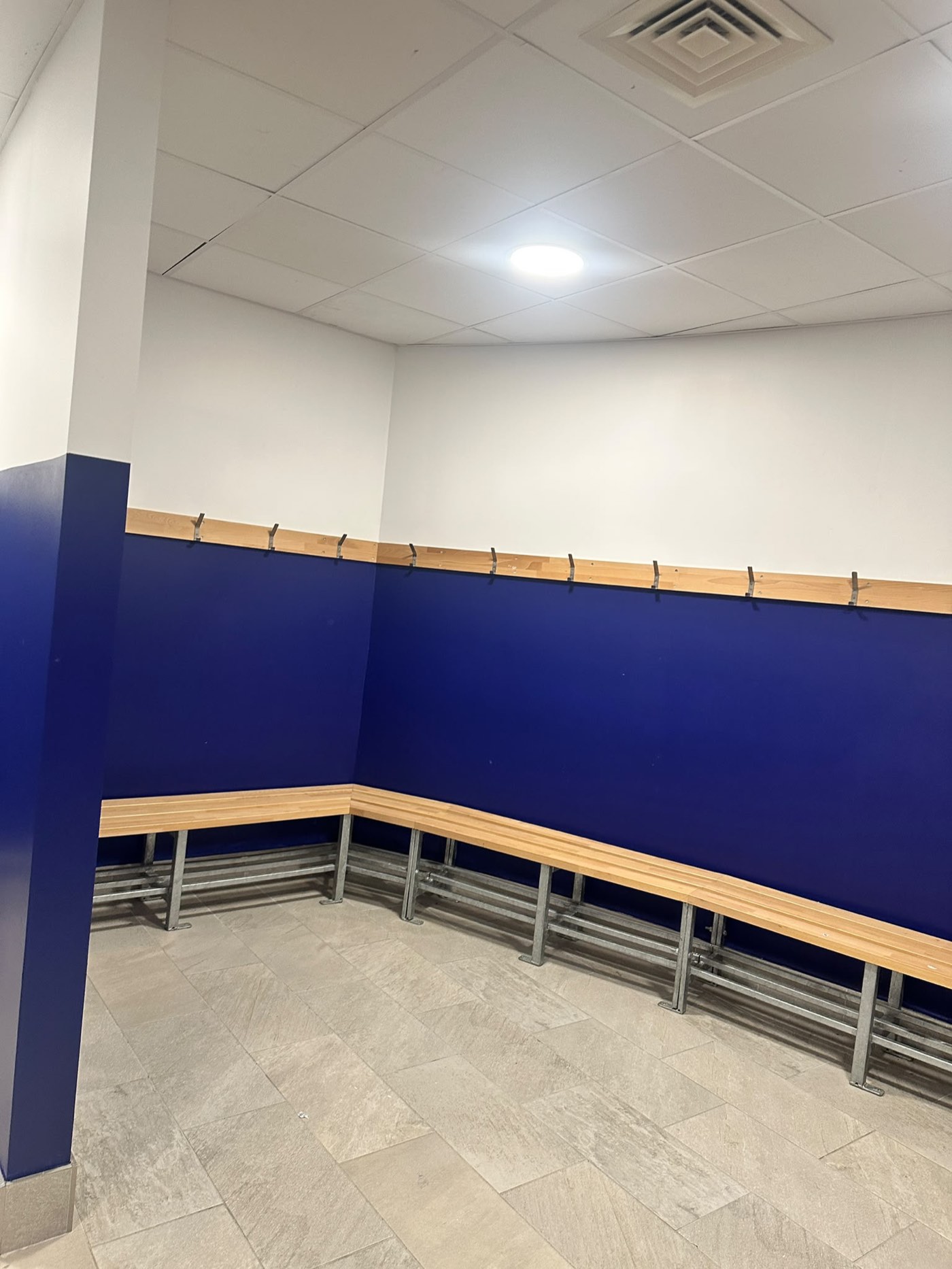 School changing room repainted in two tone blue and white with benches and coat hooks by handyman team in Dublin