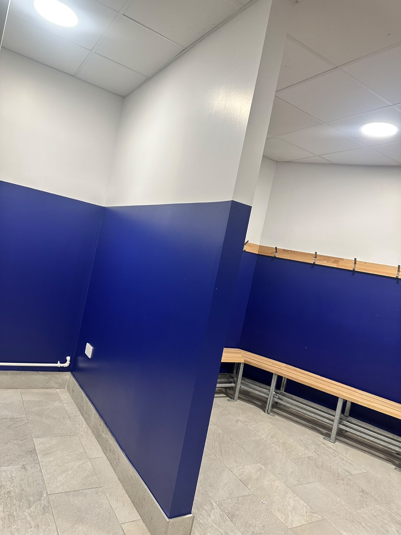 Freshly painted blue and white walls in school sports hall changing room in Dublin