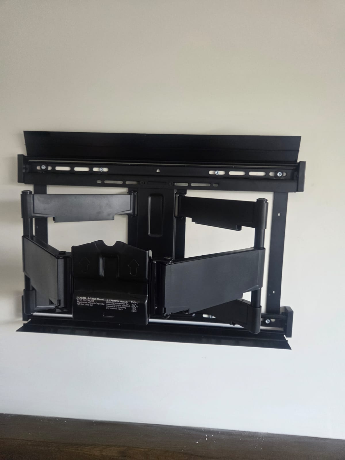Heavy duty full motion TV wall bracket fixed and levelled on the wall before the screen is fitted