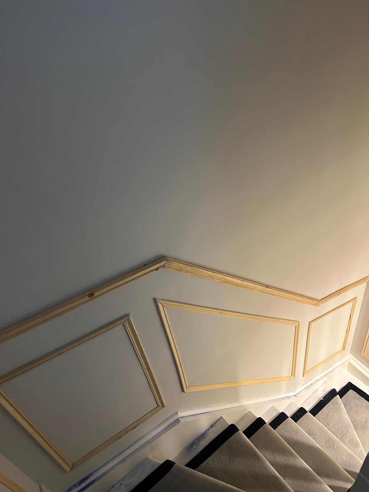 Detailed stairway wall panelling with precision cuts and trim